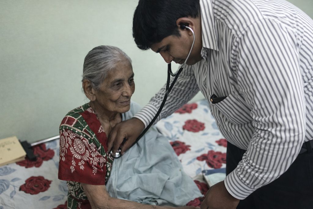 Doctor conducting health examination of an elderly resident at bedside