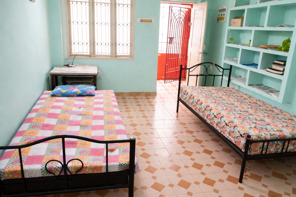Bright single bedroom with large window providing natural sunlight and fresh ventilation